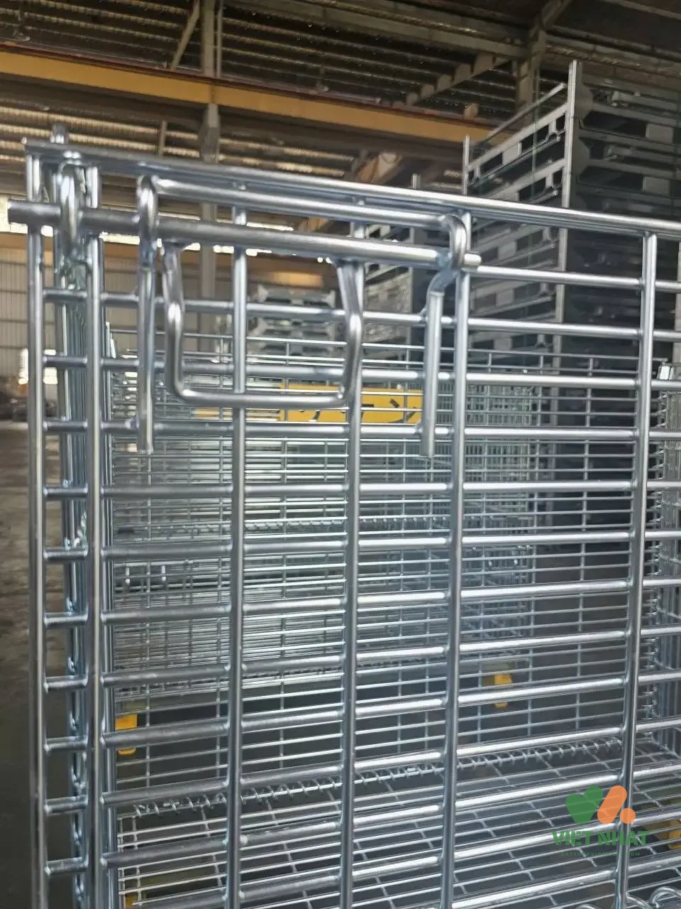 Nhân viên kỹ thuật đang kiểm tra các bản lề, chốt khóa và bánh xe của lồng sắt trước khi đưa vào luân chuyển kho.