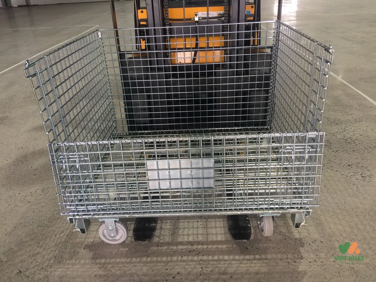 Xe nâng đang nâng pallet lưới sắt chứa đầy phụ tùng ô tô bên trong nhà máy lắp ráp